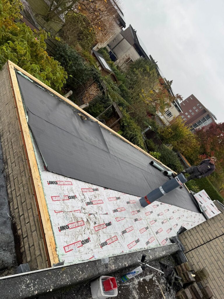 Dakisolatie met afschotisolatie en 2-laags bitumen dakbedekking tijdens een dakrenovatie in Harderwijk, afgewerkt met zinken dakranden.
