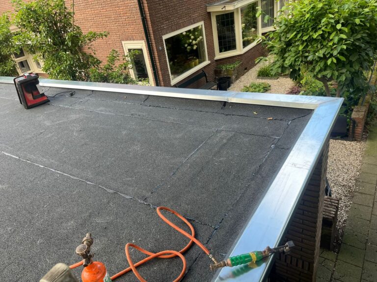 Dakoverlaging in Amersfoort met nieuwe bitumen dakbedekking en zinken deklijsten op een plat dak.