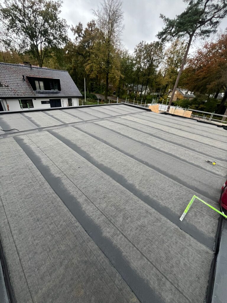Nieuw geïsoleerd plat dak met bitumen dakbedekking tijdens een dakrenovatie in Ermelo, strak afgewerkt met duurzame waterdichte aansluitingen.